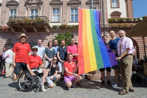 Bürgermeister Wolfgang Erichson, die Stadträte Matthias Kutsch und Andreas Grasser (v.r.) sowie Vertreter von AIDS-Hilfe und CSD Rhein-Neckar hissen vor dem Rathaus die Regenbogenfahne. Bild: Philipp Rothe, 07.08.2015