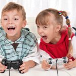 Happy children - girl and boy playing a video game